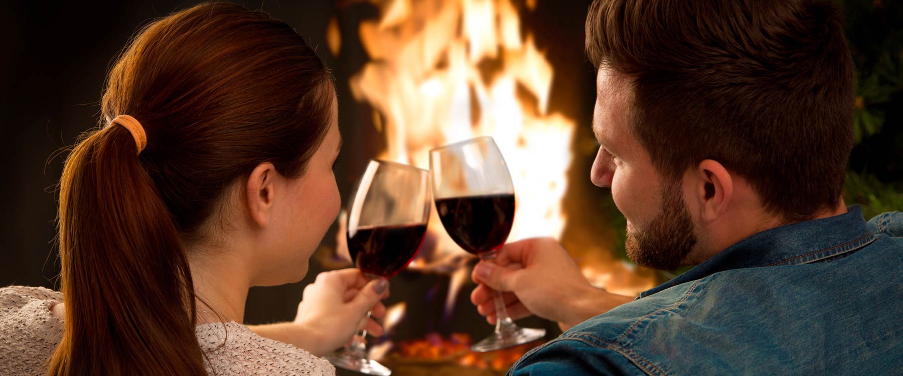 couple drinking wine by fire